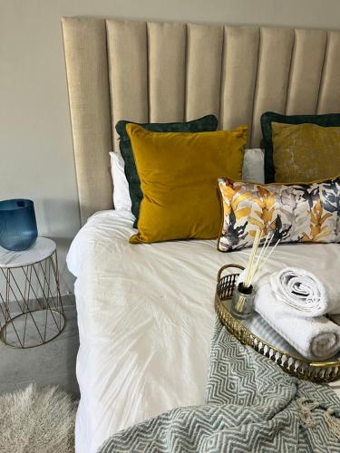 een bed met gele en groene kussens erop bij Serenity HideAway in Johannesburg