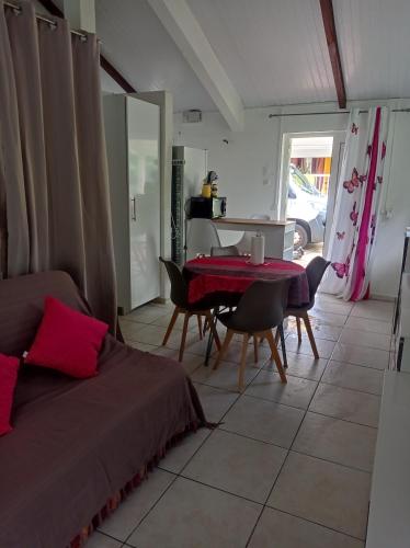 ein Wohnzimmer mit einem Bett, einem Tisch und Stühlen in der Unterkunft Villa Caracas in Lamentin