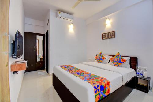 um quarto com uma cama e uma televisão em FabExpress Sky Inn em Pune