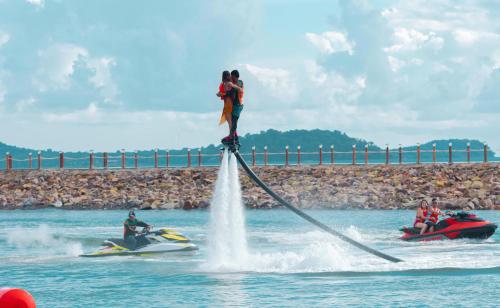 a person is standing on top of a jet ski in the water at Summer Bay Beach Club & Cabins in Sihanoukville