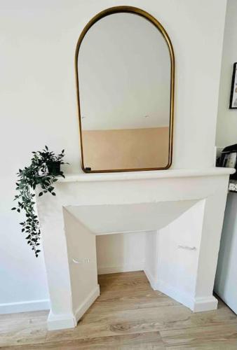 a mirror on top of a white table with a plant at Les Hortensias in Rouen
