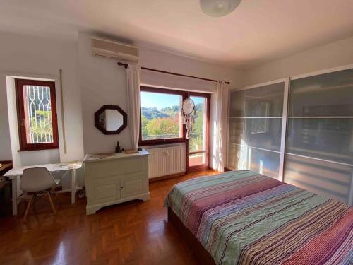 Schlafzimmer mit einem Bett, einem Schreibtisch und einem Fenster in der Unterkunft Francigena house in Rom