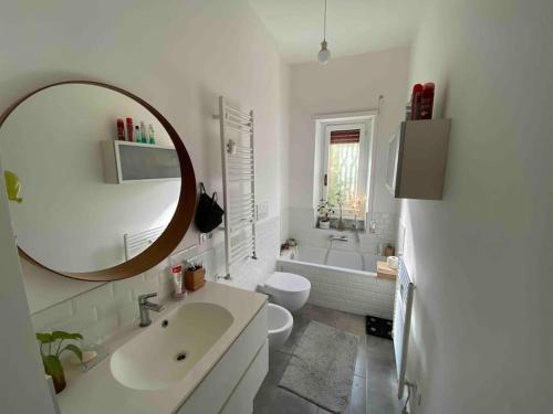 a white bathroom with a sink and a mirror at Francigena house in Rome