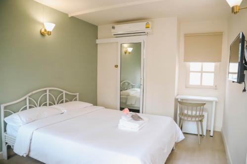 バンコクにあるWhite Lodge Hotel Bangkokのベッドルーム(白いベッド1台、鏡付)