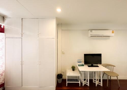 a room with a desk and a computer on a table at White Lodge Hotel Bangkok in Bangkok