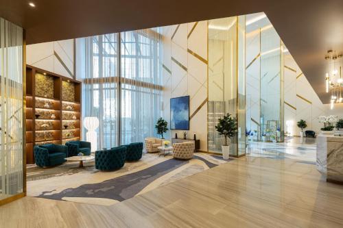 - un hall d'un immeuble avec des chaises et des tables dans l'établissement DAMAC Maison Aykon City Dubai, à Dubaï