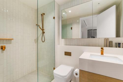 a bathroom with a toilet and a sink and a shower at Collins House Apartments by CLLIX in Melbourne