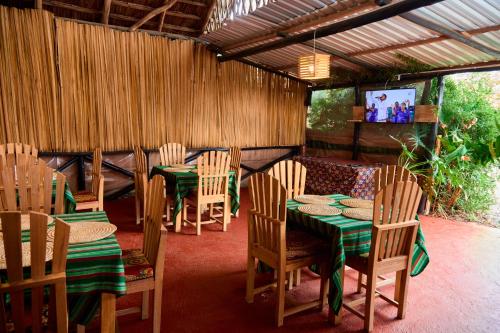 a restaurant with wooden tables and chairs and a tv at freedom inn in Arusha