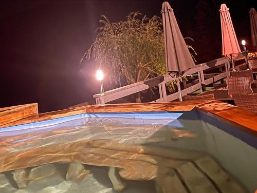 una piscina por la noche con dos sombrillas en Romanka en Żabnica