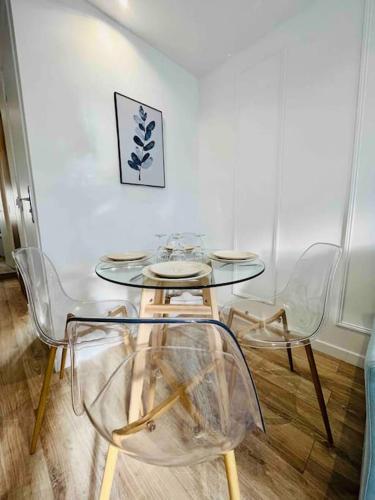 une table et des chaises en verre dans une pièce dans l'établissement Les Iris, à Rouen