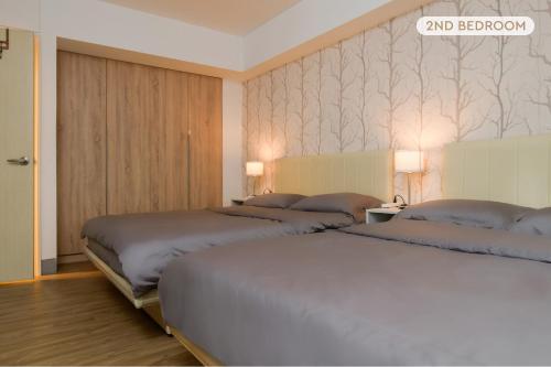 a room with two beds and a wall with wallpaper at 4B2b Clear Comfort 3min to Xinyi Anhe MRT 4房2衛 舒適明亮之家 3分到信義安和站 in Taipei