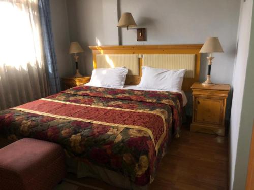 a hotel room with a bed and two night stands at Emmad Furnished Hotel in Addis Ababa