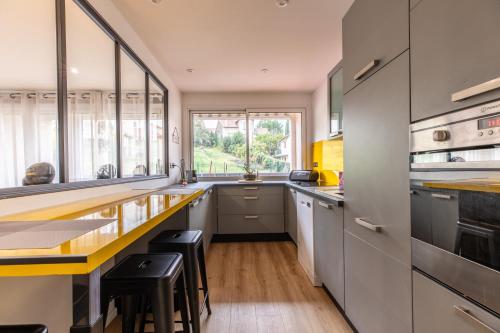 eine Küche mit weißen Schränken und einer gelben Arbeitsplatte in der Unterkunft F3 charmant neuf et équipé avec balcon "Wailly" in Clermont-Ferrand