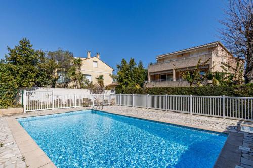 uma piscina com uma cerca e uma casa em Cap et Soleil - Happy Rentals em Antibes