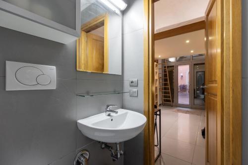 a bathroom with a white sink and a hallway at Apt Urbana 156 - Monti in Rome