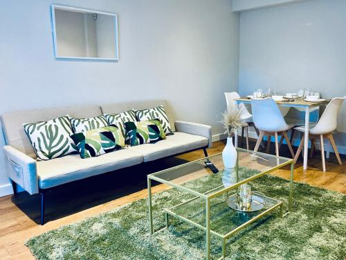Absolutely Beautiful Hemel Hempstead 2-bedroom for 1-5 Guests - contractors welcome في هيميل هيمبستيد: غرفة معيشة مع أريكة وطاولة