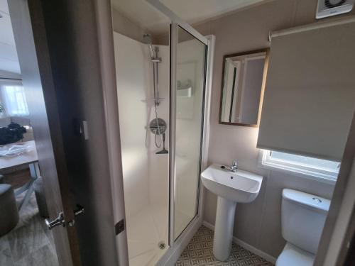 a bathroom with a shower and a sink and a toilet at Caravan in Jaywick,Jaywick sand, Clacton-on-sea in Jaywick Sands