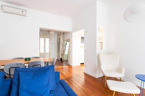 sala de estar con sofá azul y sillas blancas en Bocconi 2 camere in Stile Corte Milanese en Milán
