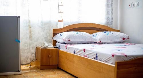 un letto con due cuscini e un telefono in una stanza di J in G Retreat Center a Dawhwenya