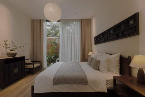 a bedroom with a large bed and a window at Nhãn Stay in Hue