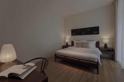 a bedroom with a bed and a desk and a table at Nhãn Stay in Hue