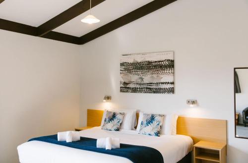 2 łóżka w pokoju z białymi ścianami w obiekcie Unit 3 Kaiteri Apartments and Holiday Homes w mieście Kaiteriteri