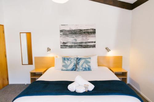 ein Schlafzimmer mit einem Bett mit Handtüchern darauf in der Unterkunft Unit 3 Kaiteri Apartments and Holiday Homes in Kaiteriteri