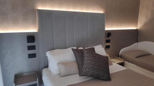 a bedroom with a bed with white sheets and pillows at Hotel Ascot Riccione in Riccione