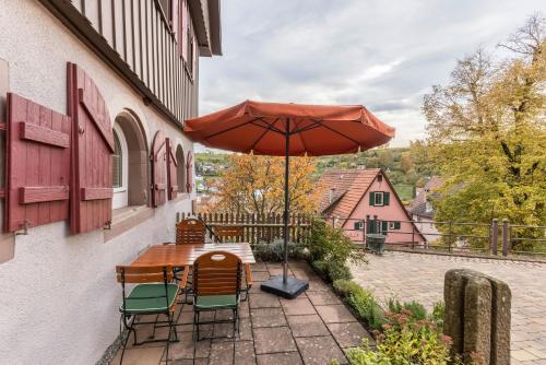 einen Tisch und Stühle mit Sonnenschirm auf einer Terrasse in der Unterkunft Ferienwohnungen Metzgerpost in Altensteig