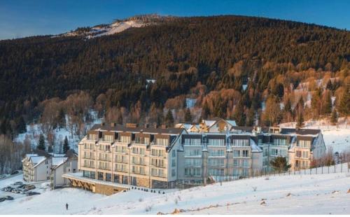 a large building in the snow in front of a mountain at RentResidence apartament in Sienna