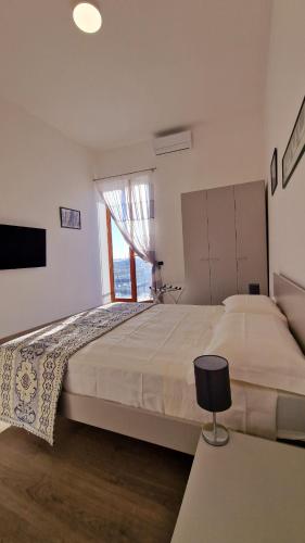 a bedroom with a large bed and a window at Puteoli Sea View in Pozzuoli