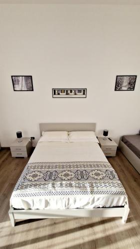 a white bedroom with a bed and two night stands at Puteoli Sea View in Pozzuoli