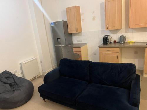 a living room with a couch and a kitchen at Central Town Apartment in Kent