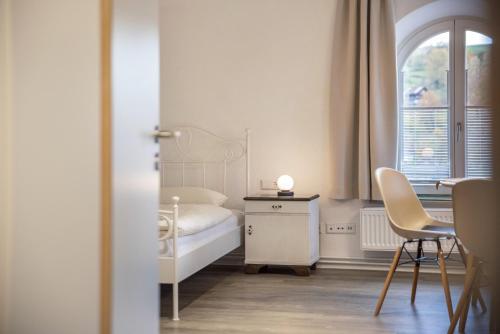 Schlafzimmer mit einem Bett, einem Tisch und Stühlen in der Unterkunft Ferienwohnungen Metzgerpost in Altensteig