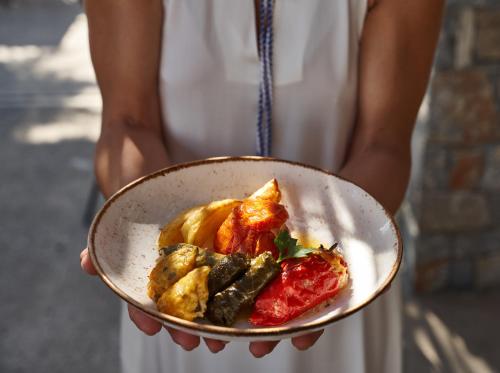 a person is holding a plate of food at Agapi Beach Resort Premium All Inclusive in Amoudara Herakliou