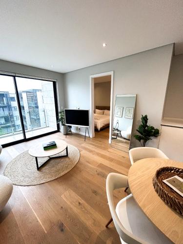uma sala de estar com uma mesa e uma televisão em Modernday Homes em Joanesburgo
