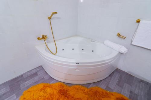 a white bath tub in a bathroom with an orange rug at Enashipai Holiday Homes in Makandara