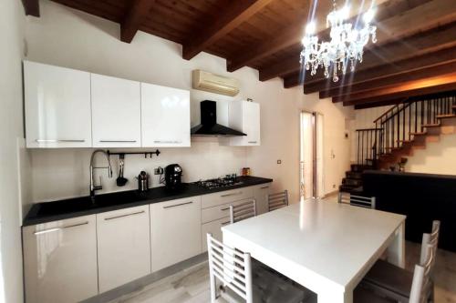 a kitchen with white cabinets and a white table at CASA FIORENTINI CESENATICO in Cesenatico