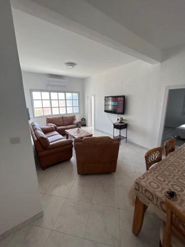 uma sala de estar com um sofá e uma televisão em Casa de Galilee em Tiberíades