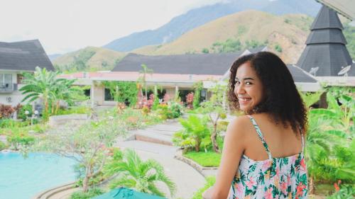 a woman in a dress standing in front of a resort at Hotel Suni Sentani - Managed by East Season in Jayapura