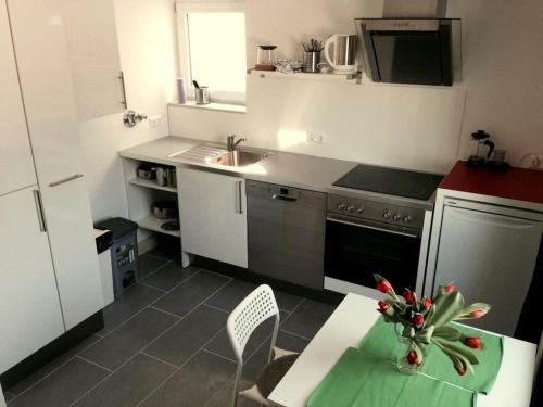 uma cozinha com um lavatório e uma mesa com um vaso em Wohnung 2 Ensingerstrtaße em Ulm