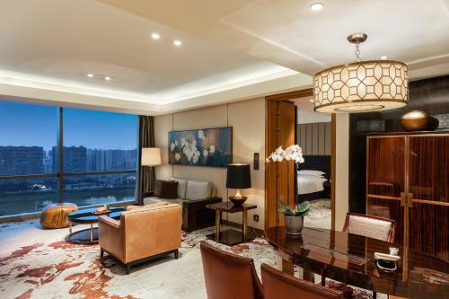 1 dormitorio y sala de estar con mesa de comedor. en InterContinental Changsha, an IHG Hotel, en Changsha