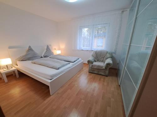 a bedroom with a bed and a chair and a window at 3-Zimmer Ferienwohnung Biggesee Sauerland nahe Olpe in zentraler, ruhiger Lage in Drolshagen