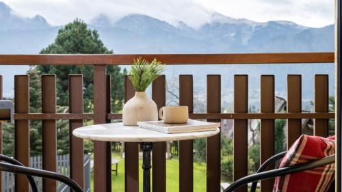 une table avec un vase au-dessus d'un balcon dans l'établissement Panorama Premium, à Kościelisko