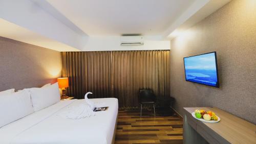 a hotel room with a bed and a television at Hotel Suni Sentani in Jayapura