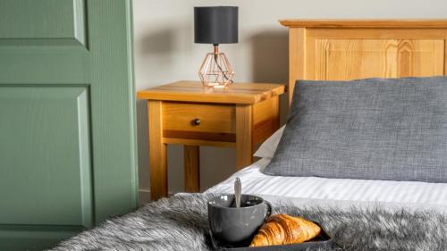 a bed with a tray of bread and a cup on it at Panorama Premium in Kościelisko