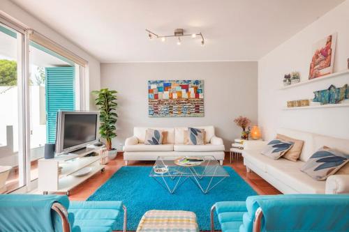 uma sala de estar com mobiliário branco e um tapete azul em Prainha Sunny 5BR Villa (up to 13 guests) em Alvor