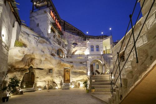 a stone building with stairs and a building with lights at My Cave Suites in Nevşehir