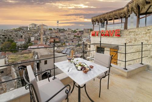 a table on a balcony with a view of a city at My Cave Suites in Nevsehir