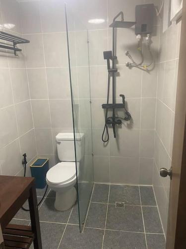a bathroom with a toilet and a glass shower stall at Angelito's Beach House 4 bedroom in General Luna